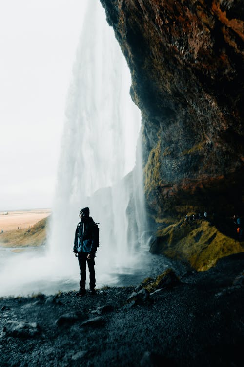 Person Standing near Waterfall