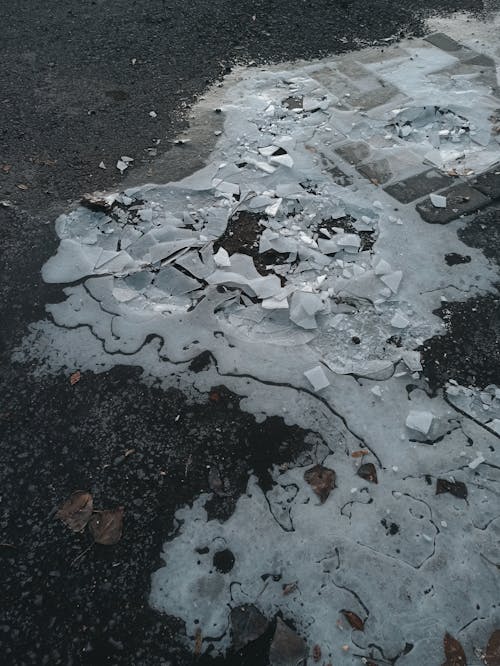 Shattered Ice of a Frozen Puddle on the Street