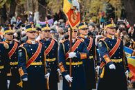 Romanian soldiers in traditional uniforms marching during a parade.