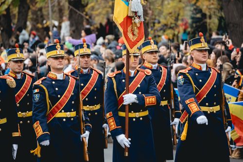 Free Romanian soldiers in traditional uniforms marching during a parade. Stock Photo