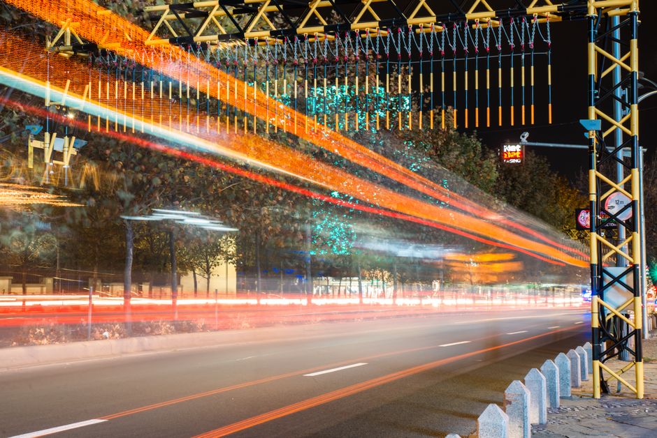 Illuminated urban scene with dynamic light trails on a busy city street at night.