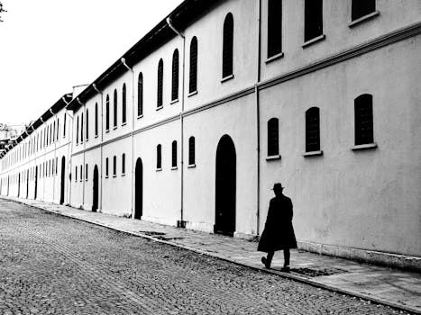 A pedestrian walks along the historic streets of Istanbul in monochrome.