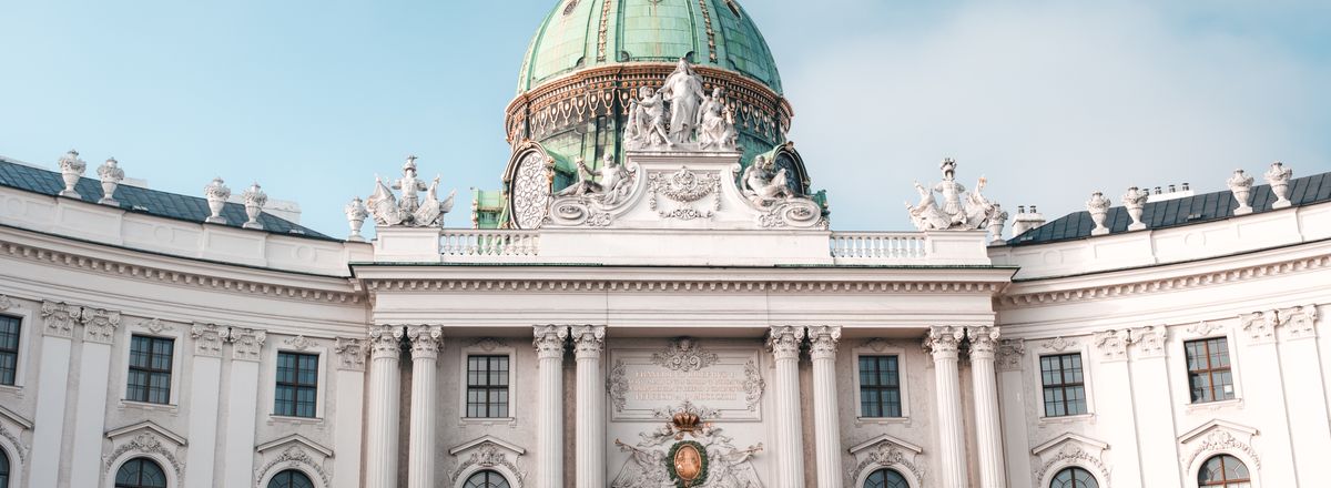 Elegant view of the Hofburg Palace's dome and facade in Vienna, Austria under a clear sky.