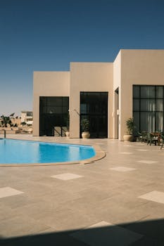 A contemporary villa featuring a luxurious swimming pool and sleek architectural design.