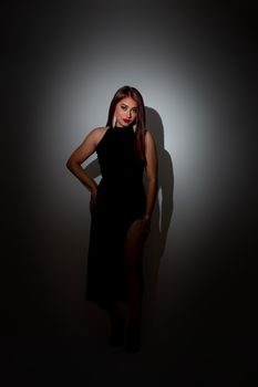 Fashion portrait of a woman in a stylish black dress, showcasing elegance and sophistication.