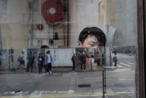Free Reflections of people and an individual in a rainy urban setting. Stock Photo