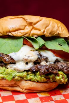 Close-up of a delicious cheeseburger with fresh toppings on a colorful background.