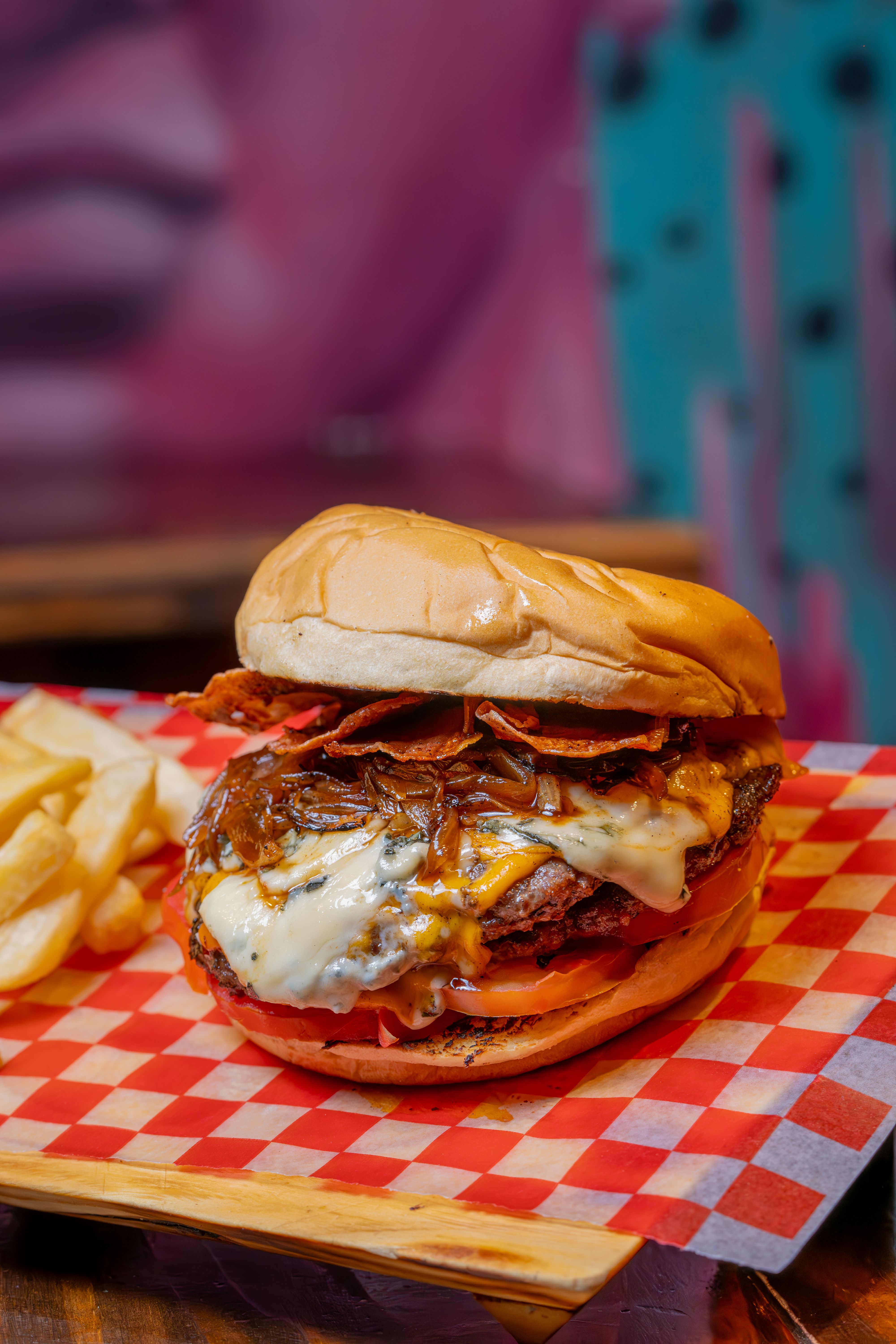 Delicious cheeseburger with crispy fries on a checkered tray, perfect for fast food lovers.