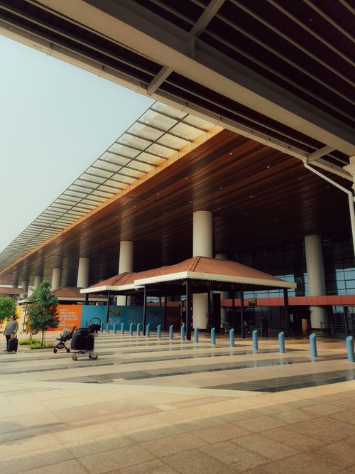 Free Contemporary airport entrance featuring colonnades and luggage carts, ideal for travel themes. Stock Photo