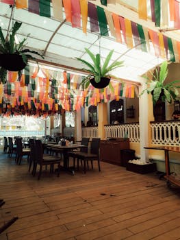 Brightly decorated restaurant with colorful banners and hanging plants, offering a festive dining atmosphere.