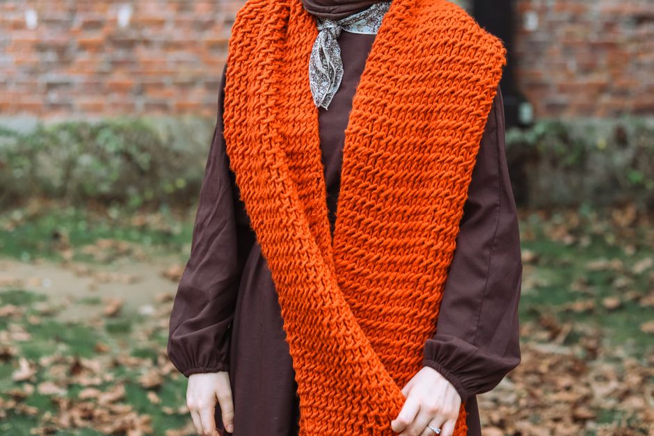 Woman wearing a chunky knit scarf styled for autumn