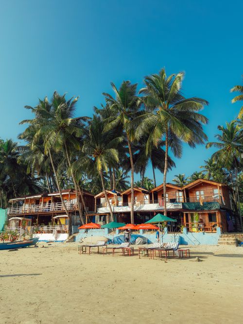 Free Idyllic beachfront resort with palm trees and sunbeds perfect for a tropical getaway. Stock Photo