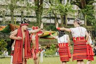 A captivating scene of adults performing a traditional dance in colorful attire outdoors.