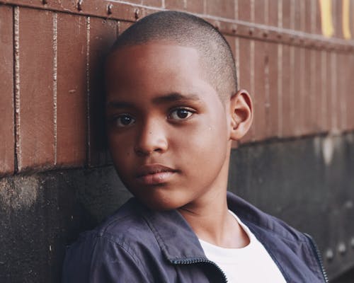 Boy Leaning on Wooden Wall