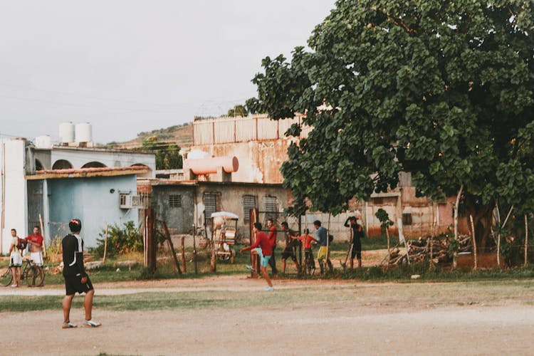 Men And Boys Playing Football On Amateur Field