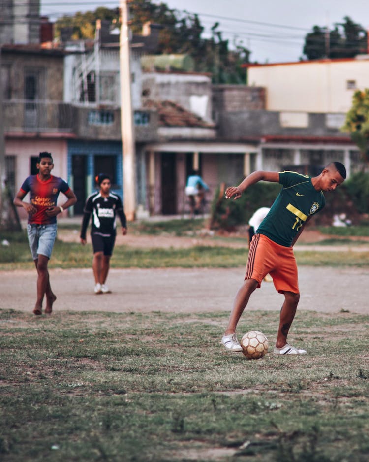 Men And Boys Playing Football On Amateur Field