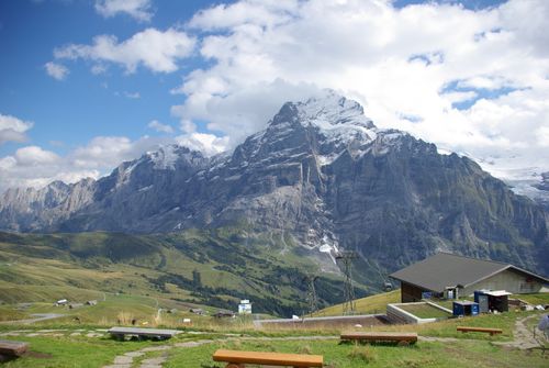 Free Scenic view of the Swiss Alps with benches and a house, showcasing natural beauty and mountain majesty. Stock Photo