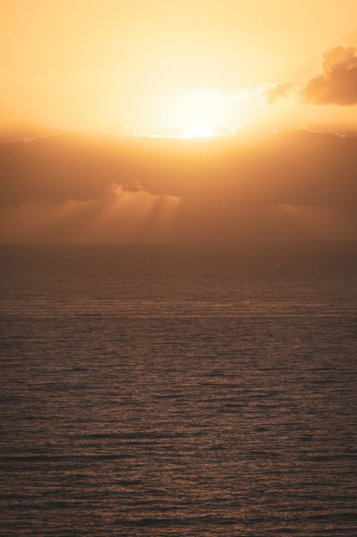 Free Beautiful sunset over the ocean in Cape Town, South Africa with a golden sky. Stock Photo