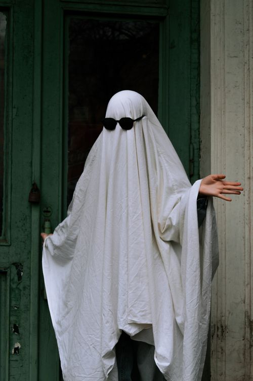 Free A person wearing a humorous ghost costume with sunglasses, suitable for Halloween fun. Stock Photo