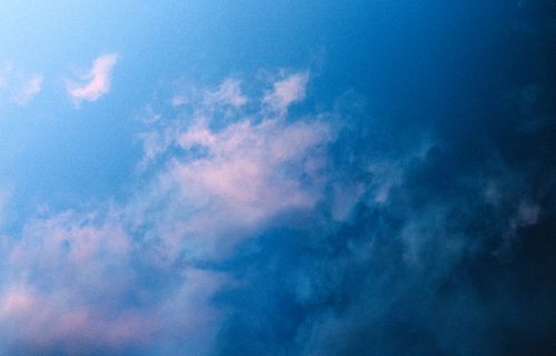 Free A tranquil skyscape featuring soft pink clouds against a vibrant blue sky. Stock Photo