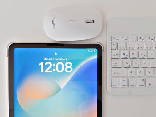 Mouse Using A Tablet Philips Wireless Mouse and Keyboard Next to the Tablet · Free Stock Photo
