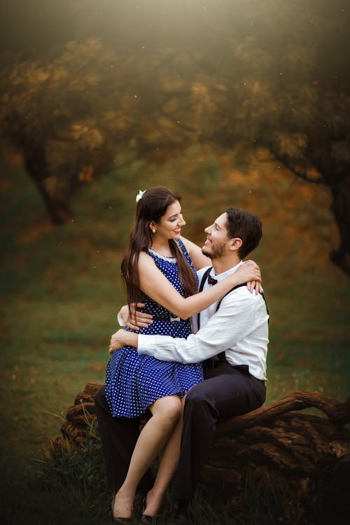 Girl Wearing Blue Dress Sitting On Man's Lap 