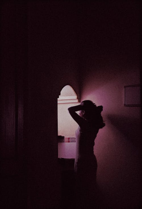 Silhouette of a Woman in a Dark Room 