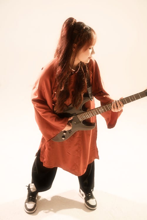 Rock Guitarist in a Red Robe with Wide Sleeves