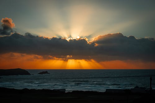 Sun Setting Over the Ocean Through the Clouds