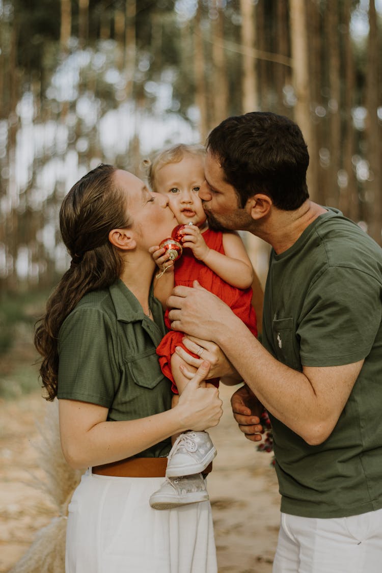 Parents Kissing Their Child