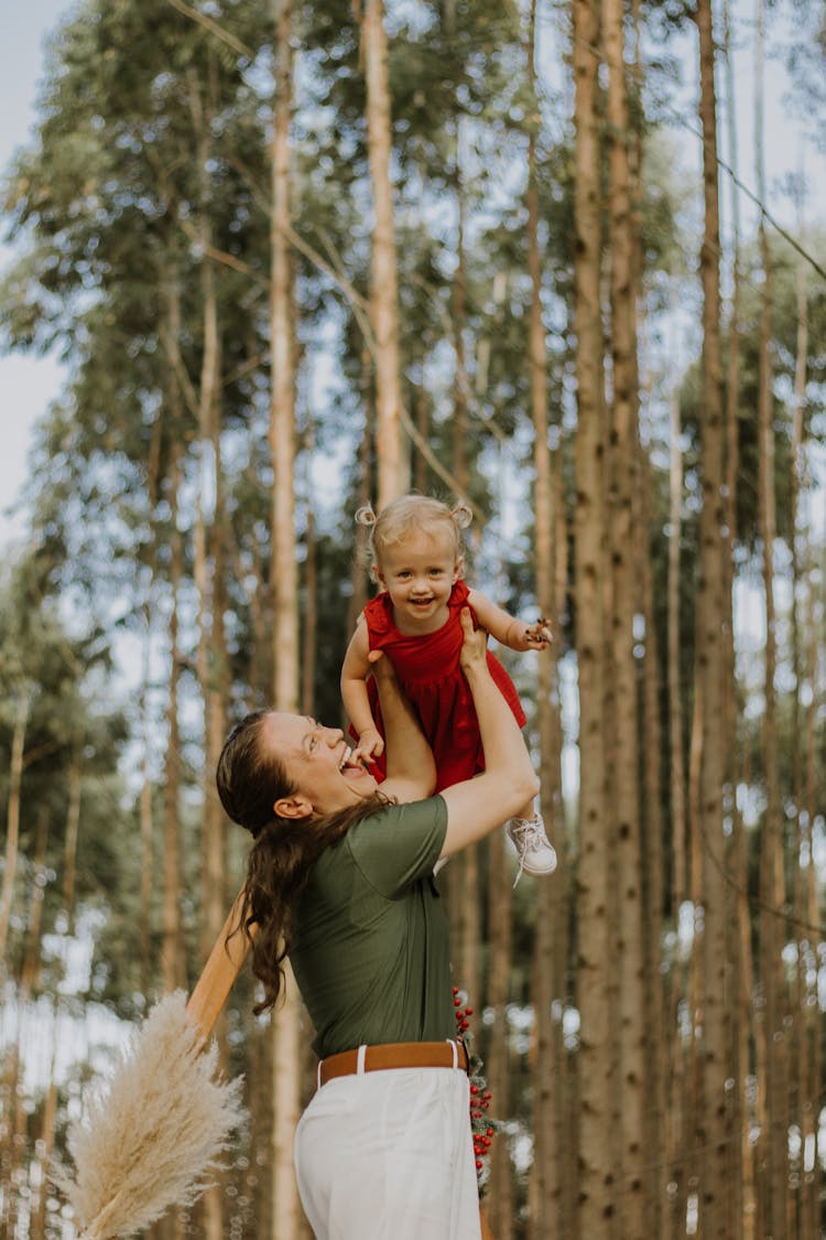 Smiling Mother Lifting Daughter