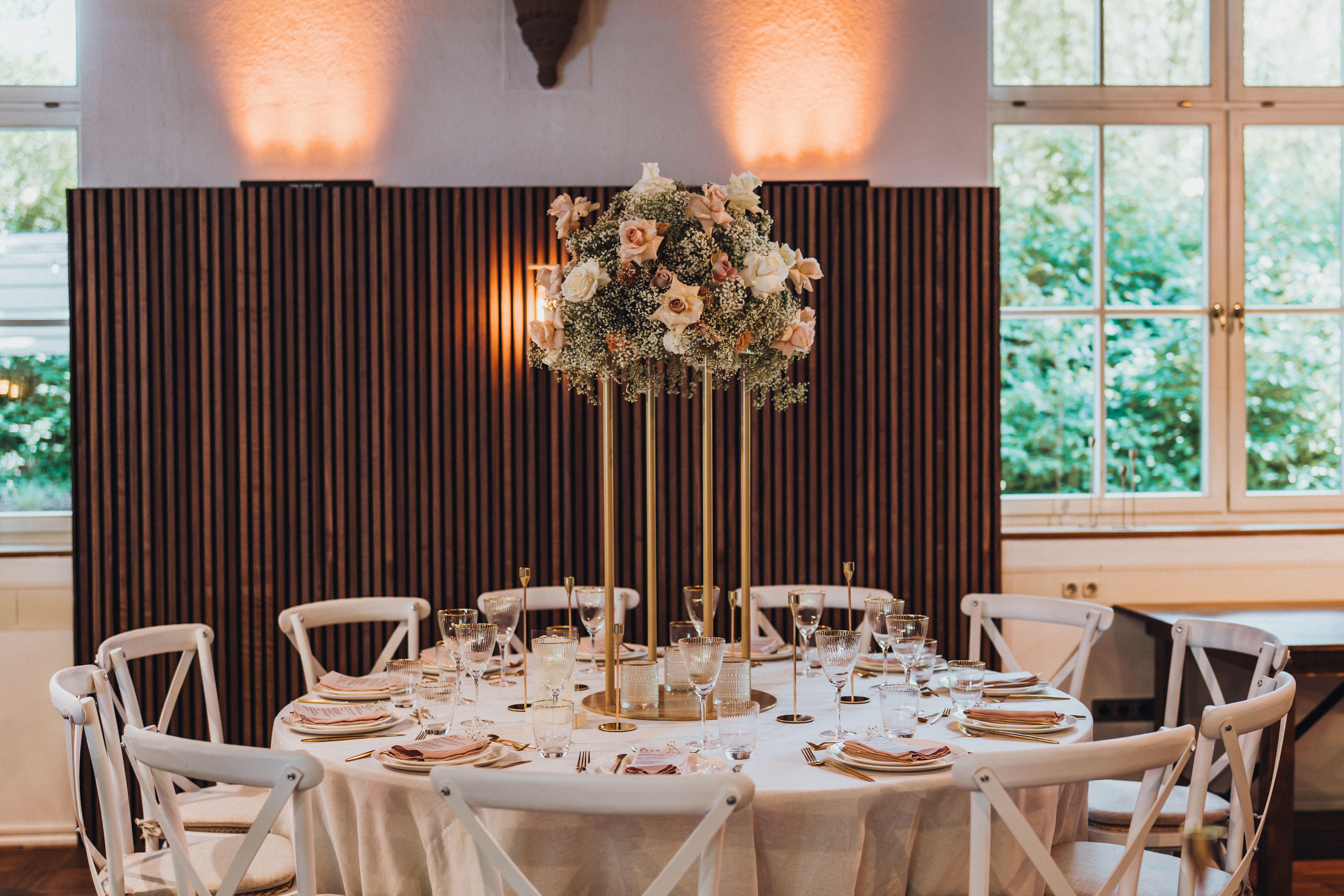 A beautifully decorated wedding reception table with floral centerpiece indoors.