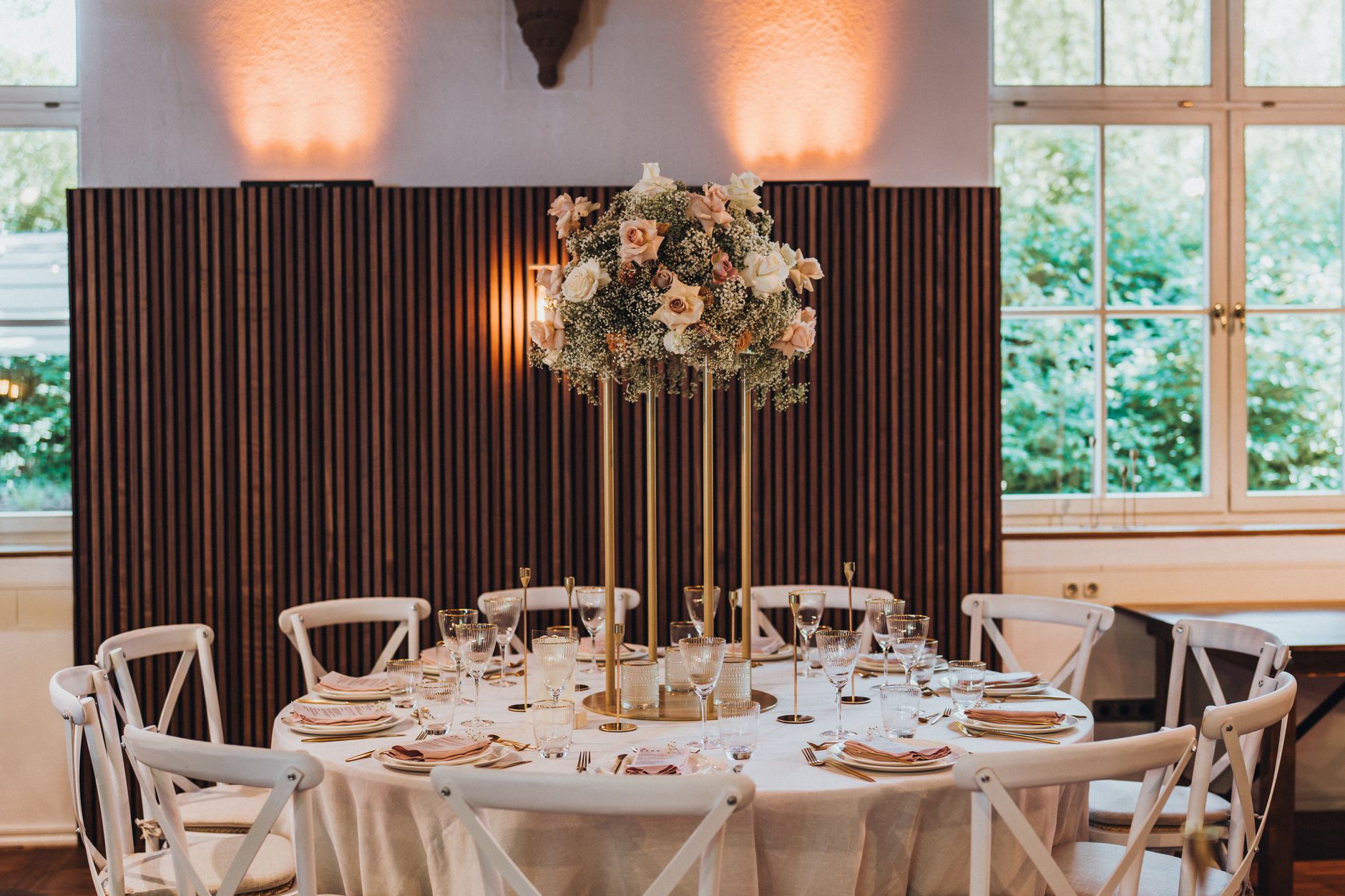 A beautifully decorated wedding reception table with floral centerpiece indoors.