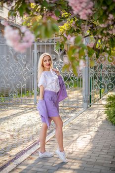 Chic young woman enjoying springtime in a vibrant garden in Istanbul.