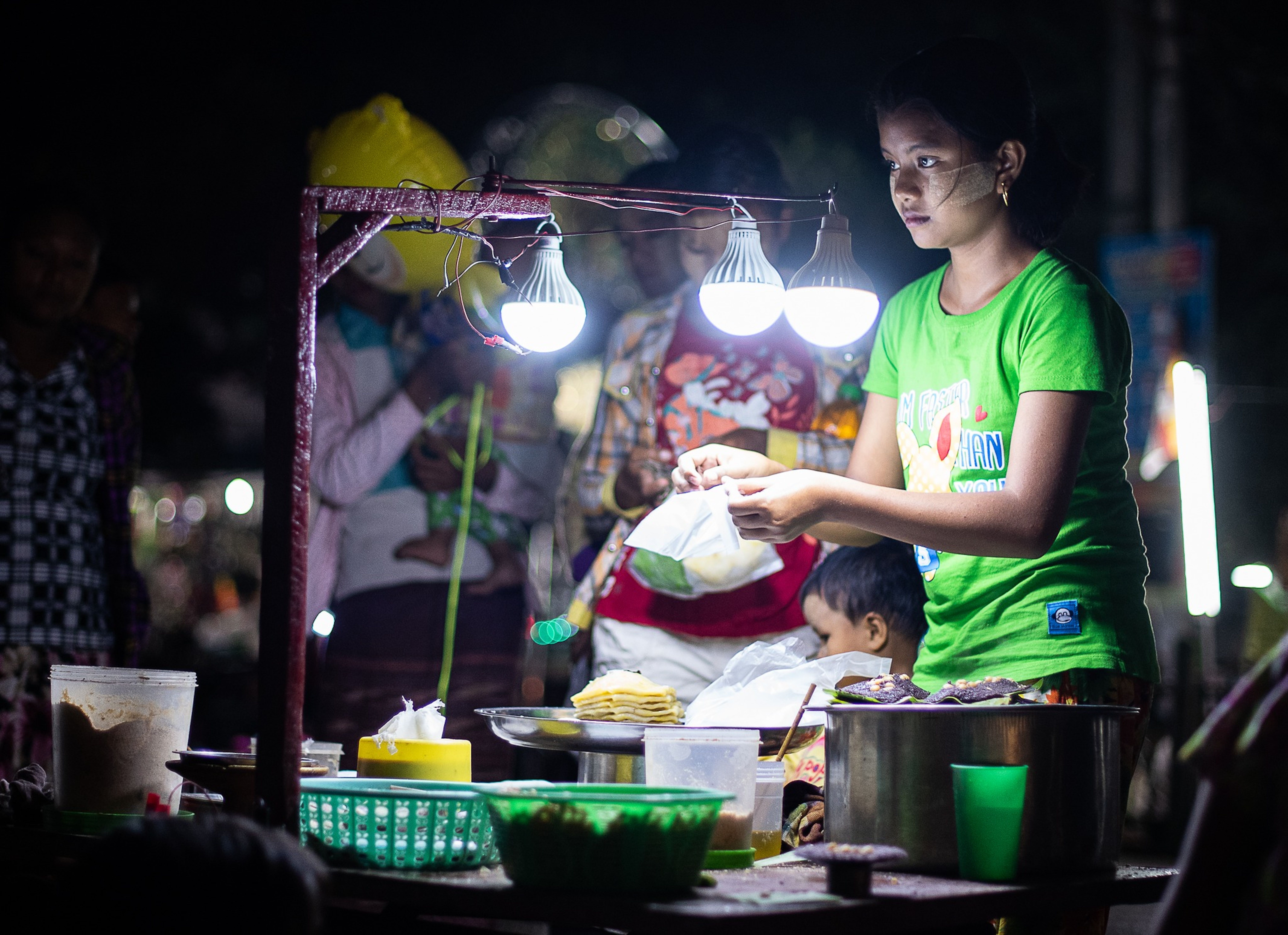 ညဘက်တွင် မီးရောင်တောက်ပသော အွန်လိုင်းကာစီနိုစခရင်ကို စမတ်ဖုန်းပေါ်တွင် ကြည့်နေသော ကစားသမား