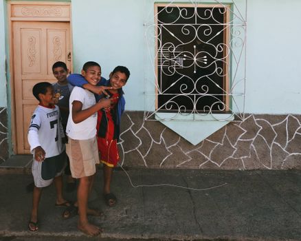 Group of happy boys playing outside a house, showcasing friendship and laughter in an urban setting.