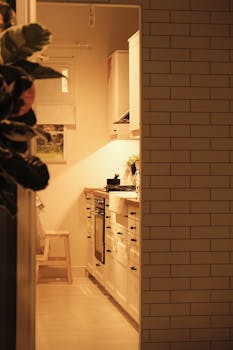 Warm and inviting small kitchen with stylish white cabinetry and modern design features.