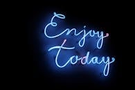 在黑暗背景的映衬下，明亮的蓝色霓虹灯与“享受今天”的字样共同营造出一种充满活力、令人振奋的气氛