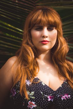 在户外自然环境中，一位红发女子头戴花饰的迷人肖像