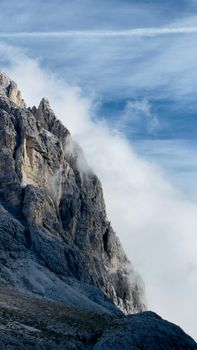 Breathtaking view of the majestic Dolomite mountain peaks under a cloudy sky in Trentino, Italy.
