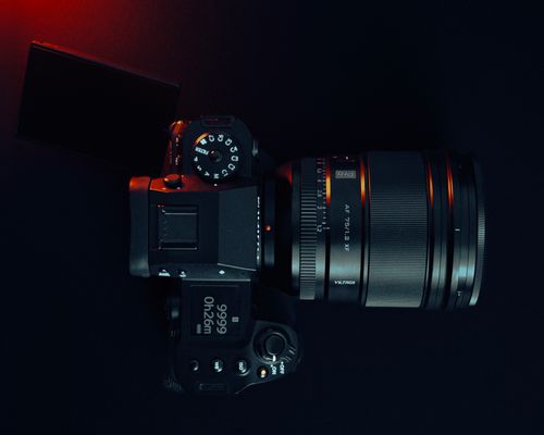 Free Top view of a professional DSLR camera with lens, showcasing modern technology in studio lighting. Stock Photo