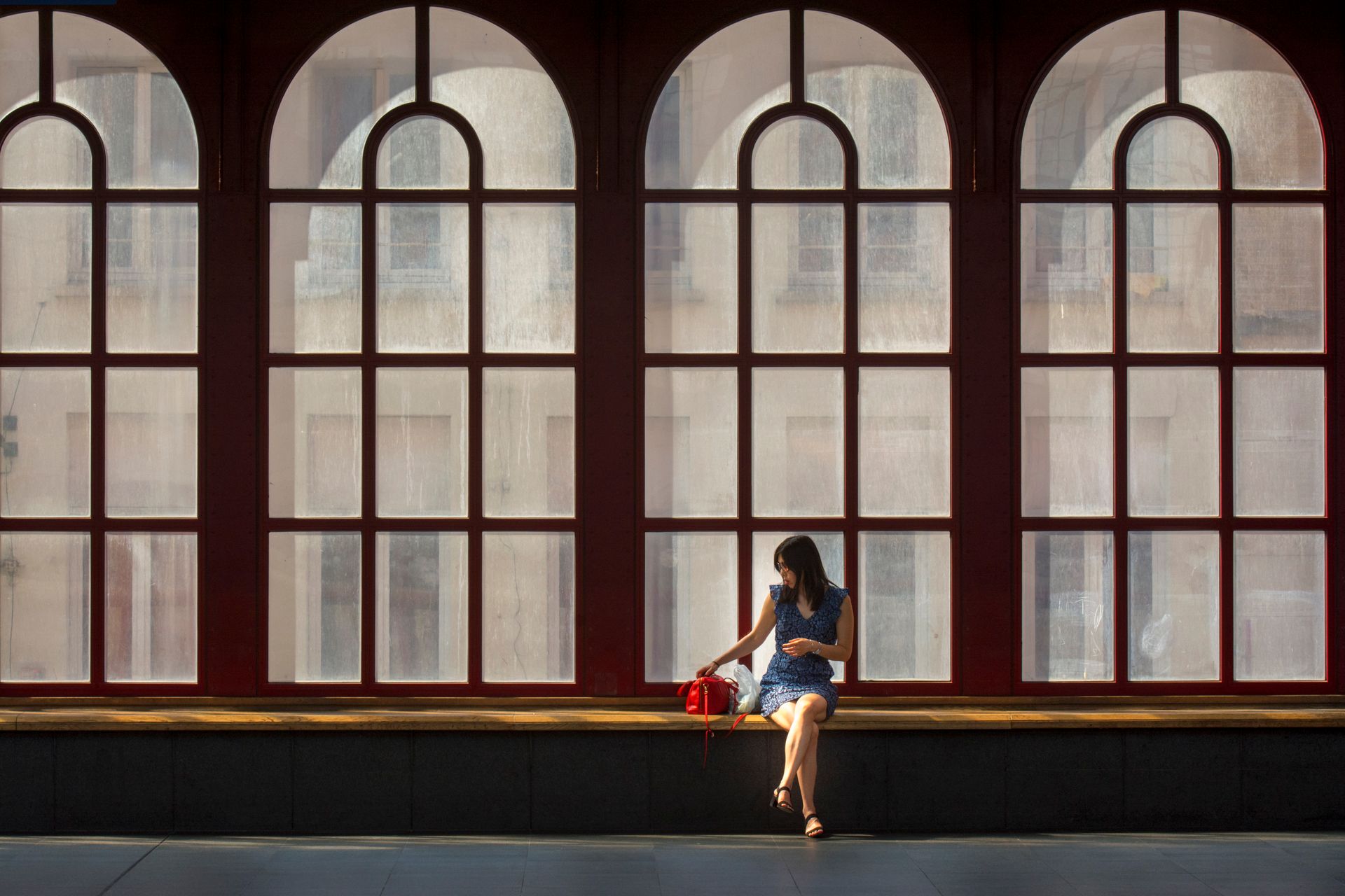 Brunette Woman Sitting by Windows in Railway Station