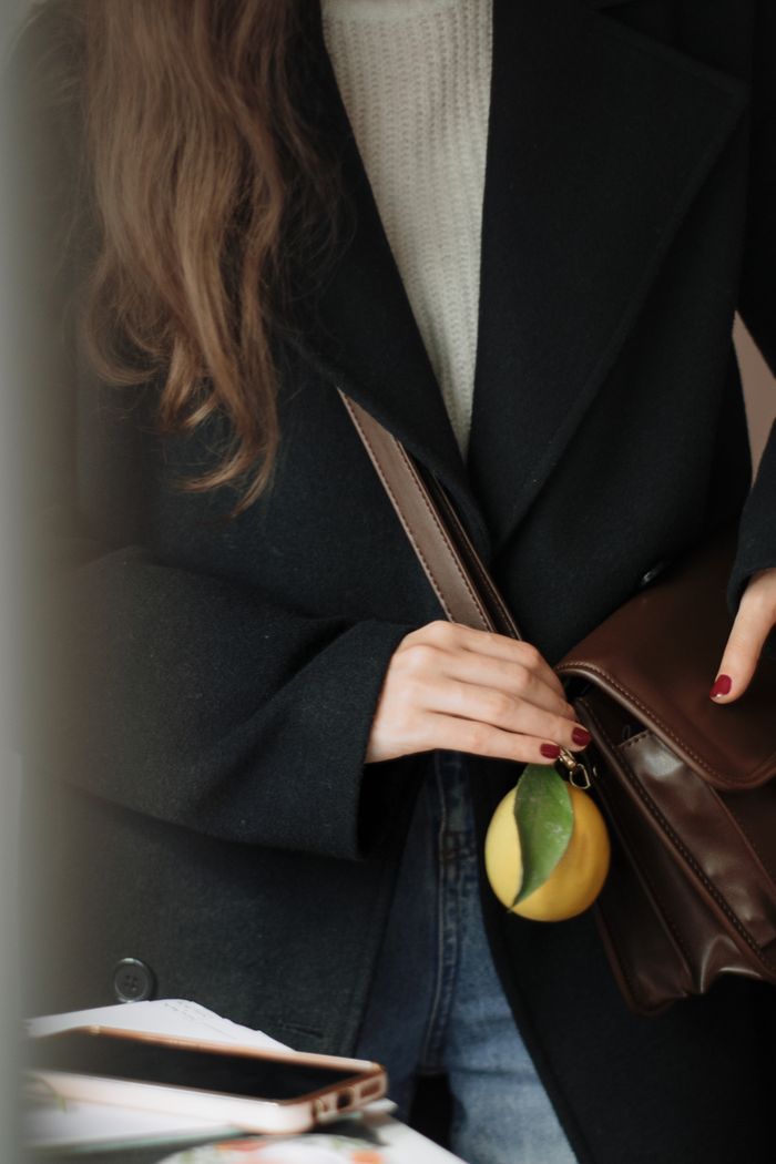 Brown leather bag with a charm keyring, by Berna on Pexels