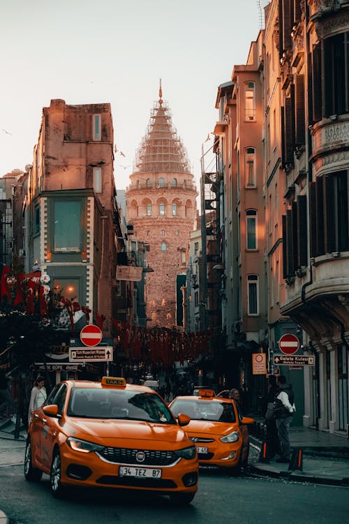 Yellow Taxis in the Street of Istanbul with a View of Galata Tower 