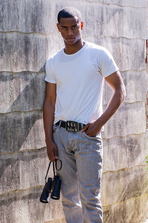 Young Man Standing with Binoculars in his Hand 