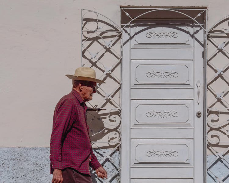 Elderly Man In Shirt Walking By White Door