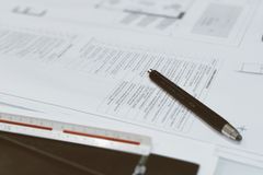 Top view of architectural blueprints, pen, and scale ruler on a designer's desk, showcasing a creative workspace.