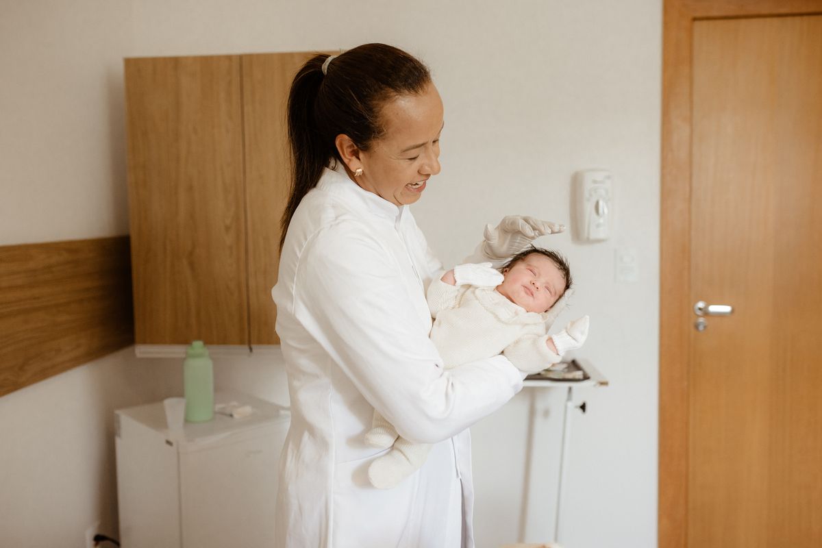 Pediatric nurse holding a newborn baby