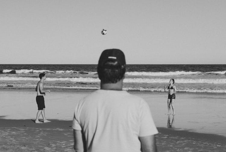 People Playing Ball On Beach In Black And White