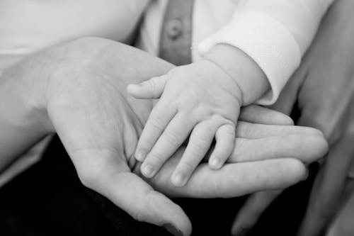 Free Woman Holding Hand of Her Child in Black and White Stock Photo